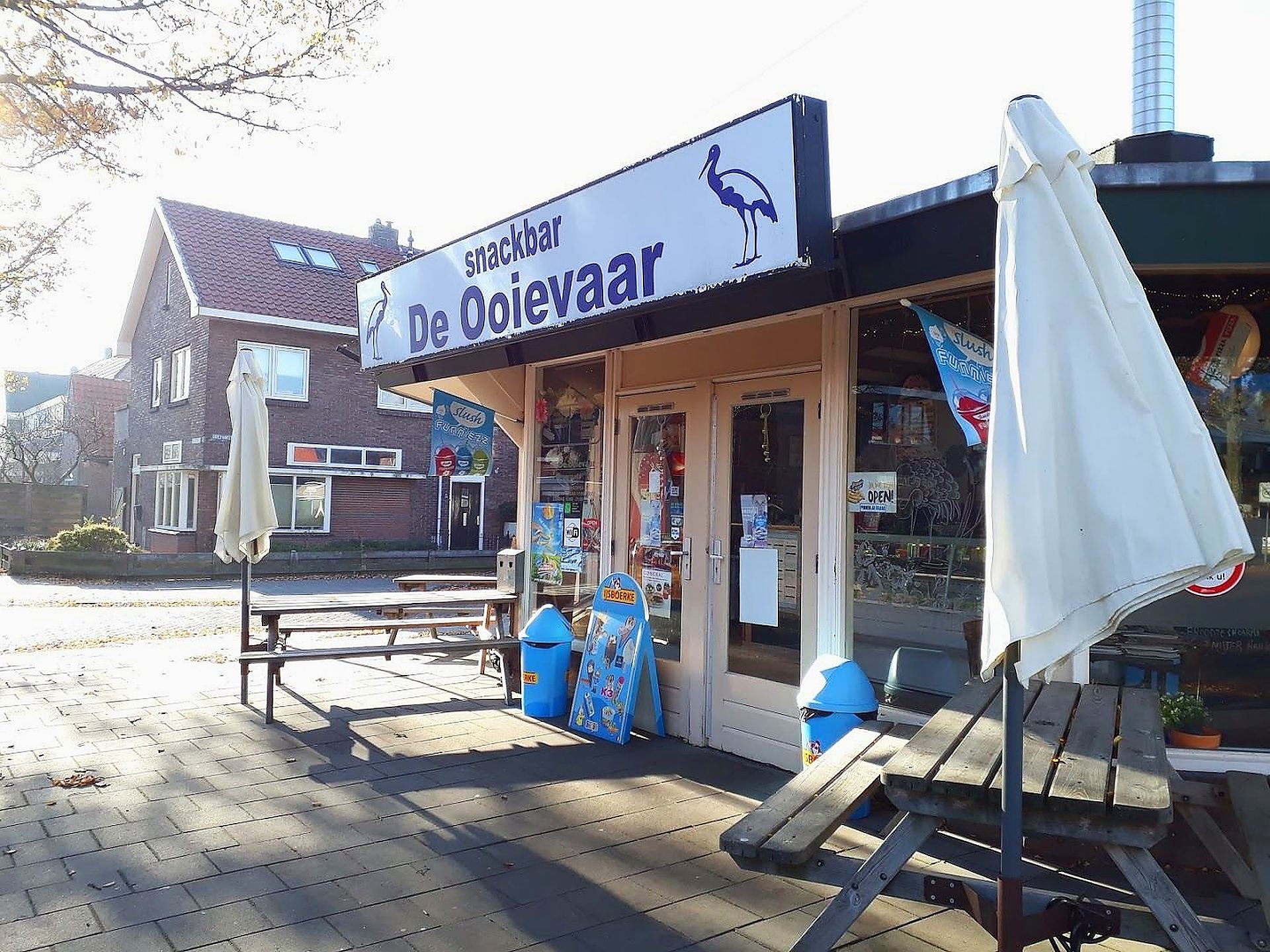 De zaak van De Ooievaar: terras, picknickbanken en het gevelbord